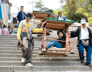 参拝客を乗せ急な石段を下りる、こんぴら名物「石段かご」＝いずれも香川県琴平町で