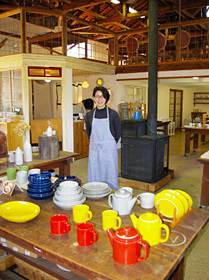 窯元の倉庫の雰囲気を残した「南創庫」と池田真美さん＝いずれも長崎県波佐見町で