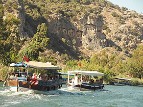 観光ボートでダルヤン川を上る。山の中腹に、カウノス遺跡の岩窟墓が見える＝トルコ・ダルヤンで