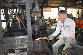 包丁づくりを実演する田中勝人さん。観光客の体験プログラムもある＝長崎県大村市で