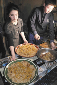 ウズベク人の国民食「プロフ」を盛り付ける料理人ら＝シャフリサブスで