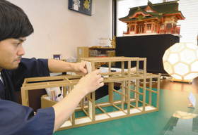 山鹿灯籠の制作を実演する中村潤弥さん。キットを組み立てる約２時間の制作体験もできる＝山鹿市の山鹿灯籠民芸館で