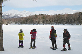 スノーシューを履き、凍った湖の上から知床連山を見る＝北海道斜里町で