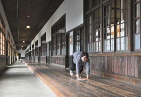 旧小学校校舎の１０９メートルの廊下で、雑巾がけレースを体験する人＝愛媛県西予市で
