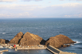 竜飛崎の近くから、津軽海峡をはさんで北海道の渡島半島を望む。手前の岩は「帯島」と呼ばれ、義経が蝦夷に渡る際にここで帯を締め直した、との伝説がある＝いずれも青森県外ケ浜町で