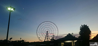 星見草／東京都足立区　「またいこうね。」　大切な友達とまたいこうね。と約束したときの写真です。観覧車と月と街灯がバランスよく写るようにしました。もうあとちょっとで沈んでしまう夕陽の光がほんのちょっと写ってる時間。そして、またいこうね。って約束した特別な場所。