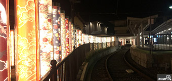 まゆ／愛知県名古屋市　「引き継がれる帯が、列車を未来に見送る」　過去の人間が見送っている様で、幻想的でした。　駅と帯(着物フォレスト)。帯が列車を見守る樹々の様でもありました。