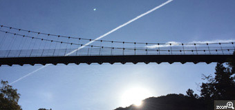さくらこ／愛知県清須市　「ひこうき雲」　太陽と月　多良峡のつり橋です。太陽と月、ひこうき雲が一直線に引かれ、自然の中に書きこまれる。