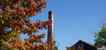 みーな／愛知県知多郡南知多町　「煙突のある風景」　常滑の窯のある広場の高い煙突が青空にそびえ立っていて目を惹きました。　紅葉した木の葉を入れて、赤、青、茶色のコントラストを強調しました。