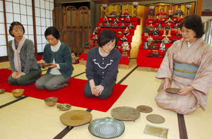 若手窯元が手掛けた菓子器（手前）に見入る来場者たち＝越前町小曽原の県陶芸館茶苑で