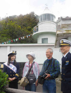 神島灯台を案内する一日灯台長の水谷さん（左）＝鳥羽市沖の神島で