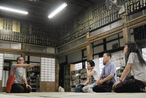 集まった作家たちに寺について説明する住職の今井さん（左）＝金沢市瓢箪町で