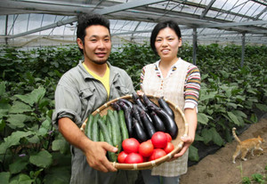 農園で採れたトマトなどを抱える北川さんと婚約者＝多気町丹生で