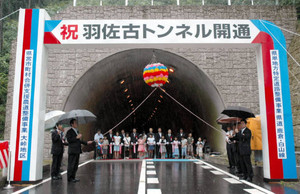 テープカットをして羽佐古トンネルの開通を祝う関係者ら＝郡上市美並町白山で