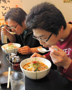 グランプリに出品されたラーメンを食べる男性客ら＝松阪市宮町のラーメン店で