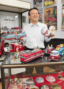 昔懐かしいおもちゃを手にする川口孝嗣さん＝刈谷市郷土資料館で