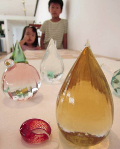「リングレスト」など、さまざまな色や形のガラス作品が並ぶ作品展＝射水市大島絵本館で