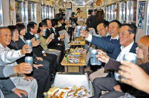 電車に揺られながら乾杯する居酒屋電車の乗客たち＝福井市のフェニックス通りで