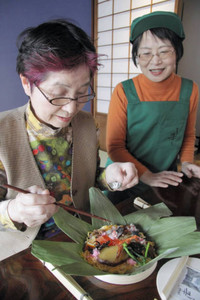 森田さん（右）のアドバイスを受けながら押しずしづくりに励む女性＝金沢市東山で