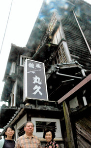 今秋にも取り壊されることになった丸久旅館の前に立つ（左から）柏野さん、井上豊さん、恵美子さん＝常滑市鯉江本町で