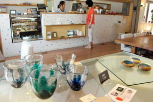  カフェの店内に並ぶ学生５人のガラス作品＝富山市古沢で