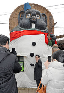 雪だるま姿で観光客らを出迎えるタヌキのモニュメント＝甲賀市信楽町で