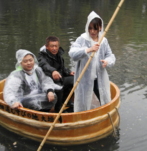雨の中、本番に向けて船頭の練習をする学生＝大垣市の水門川で