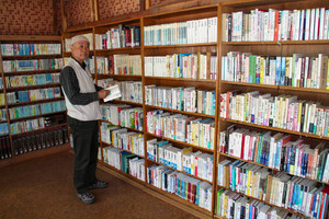よみかき交流文庫の本を整理する清水さん＝南木曽町で