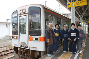 松阪木綿を着て名松線の電車で出発する別所代表（左）ら＝ＪＲ松阪駅で