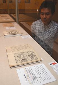 バラが登場する文献が並ぶ企画展＝明和町竹川の斎宮歴史博物館で