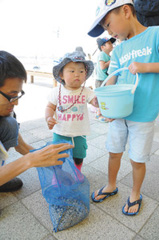 砂利入りの網袋を用意する参加者たち＝いずれも浜松市西区舞阪町弁天島で