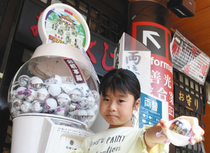 おみくじと模型が入った「ガチャみくじ」を楽しむ参拝客の子ども＝長野市元善町の善光寺で