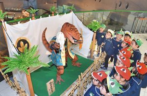 お披露目された恐竜の五月人形に興味津々の園児たち＝勝山市の県立恐竜博物館で