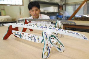 最上進さんが制作した九谷焼の日本刀＝能美市九谷焼陶芸館で