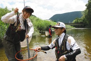 振草川で釣り上げたアユを手に笑顔の奥田さんと講師の丹羽浩和さん