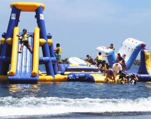 海上に設置された滑り台やシーソーを楽しむ子どもたち＝伊東市のオレンジビーチで