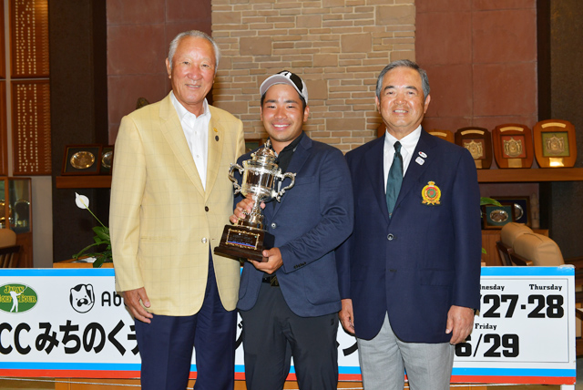 表彰式には青木会長も駆けつけた。男子ゴルフ再生への意気込みが感じられる。青木会長、田村社長に囲まれて会心の笑顔で写真に納まる比嘉一貴。