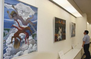 戦争や原爆の恐ろしさを描いた絵画が並ぶ会場＝輪島市文化会館で