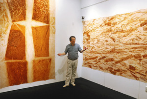 鉄さびを布に写し取った作品を解説する長谷さん＝若狭町熊川の熊川宿若狭美術館で