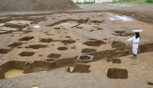 奈良時代の倉庫とみられる柱跡が見つかった福満遺跡。奥は古墳時代の竪穴住居＝彦根市小泉町で