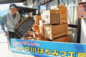 養蜂器具を手に参加を呼び掛ける富永さん＝中川村で