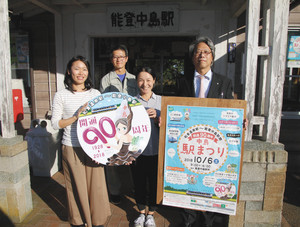 記念ヘッドマークとポスターを手に来場を呼び掛ける実行委のメンバーら＝七尾市中島町浜田で