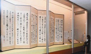 「信濃の国」の歌詞をつづった浅井直筆のびょうぶ（左）などが並ぶ会場＝松本市丸の内の市立博物館で