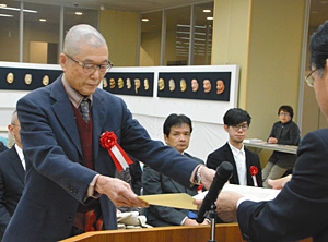 表彰状を受け取る受賞者（左）＝金沢市広坂の金沢能楽美術館で