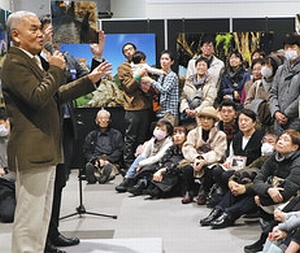 多くの来場者を前に撮影の裏話を披露する岩合さん（左端）＝長野市