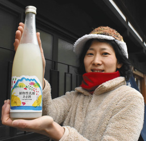 新発売の「植物性乳酸あま酒」を手にする山口さん＝木曽町の中善酒造店で