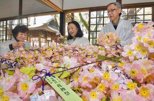 造花の桜の小枝作りに励む女性たち＝敦賀市の金崎宮で