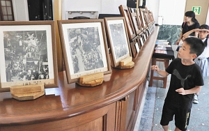 昭和初期の山車や大神輿の写真に見入る子どもたち＝坂井市の旧森田銀行本店で