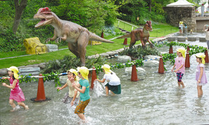 恐竜ロボットが置かれたジャブジャブ池で水遊びを楽しむ園児たち＝安城市赤松町のデンパークで