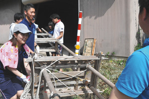 組み立て前のキリコを倉庫から運び出す金沢星稜大の学生ら＝穴水町沖波で